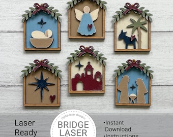 May include: Six wooden ornaments featuring nativity scenes, including an angel, a manger, a donkey, a star, a building, and figures. Each piece has a green leafy arch with a dark red bow at the top, layered with various colors like blue, tan, and red.