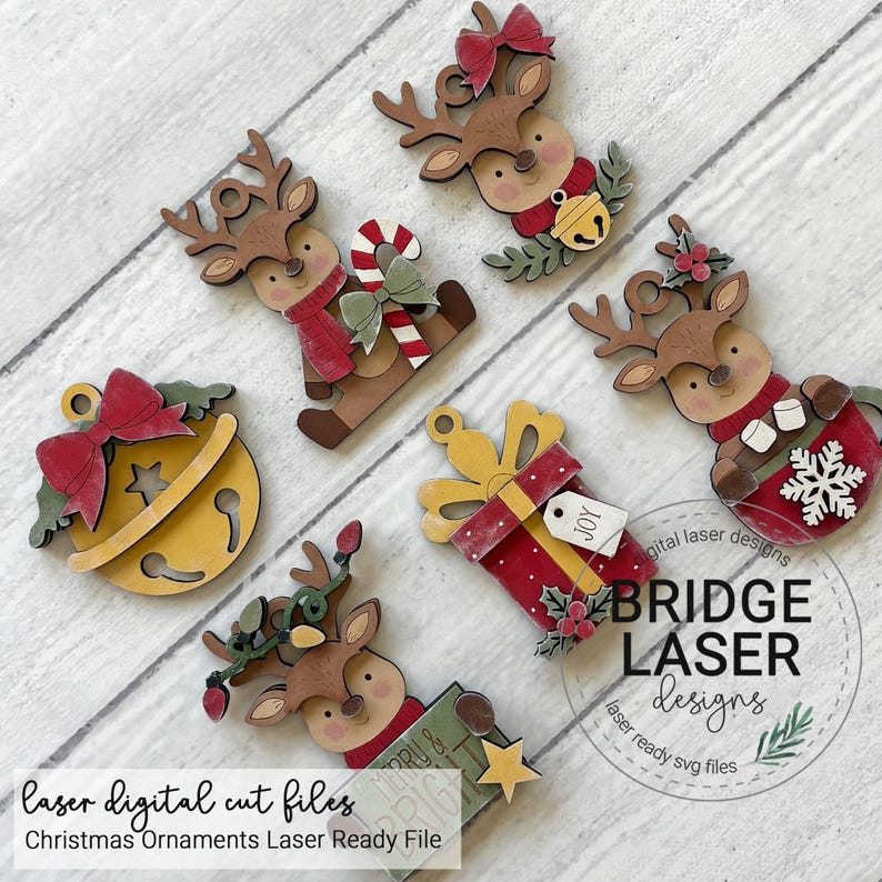 May include: A collection of six wooden Christmas ornaments featuring reindeer, a jingle bell, and a gift box. The reindeer designs include accessories like a candy cane, a snowflake, and string lights. Each ornament has a hole for hanging.