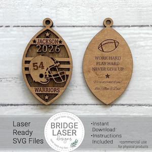 May include: Two football-shaped wooden ornaments with laser-cut designs. The left ornament features the name JACKSON, the year 2026, the number 54, a football helmet, and the word WARRIORS. The right ornament displays a football and the text WORK HARD PLAY HARD NEVER GIVE UP, along with the phrase We're so proud of you! Love, Mom & Dad.