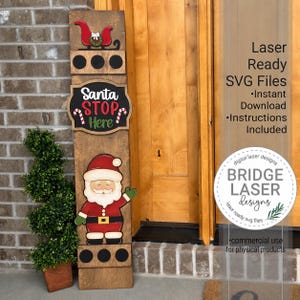 May include: A tall, rectangular wooden porch sign featuring a red sleigh, a black sign with the white and red text Santa STOP Here, and a cartoon Santa Claus figure. The sign includes circular cutouts and decorative candy cane accents.