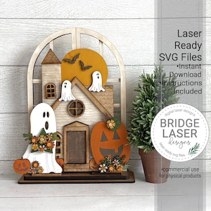May include: A wooden Halloween house decoration featuring a pumpkin, ghosts, and bats. The house has a door, windows, and a round sun. The text "Laser Ready SVG Files" and "BRIDGE LASER Designs" are also visible.