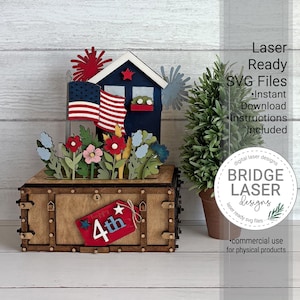 May include: A wooden box base with a red tag labeled 4th, topped with a blue house, an American flag, red and blue firework cutouts, and colorful flowers. The text reads Laser Ready SVG Files, Instant Download, Instructions Included.