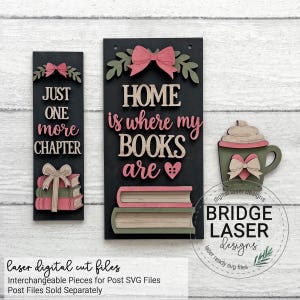 May include: Two rectangular black wooden signs and a mug-shaped cutout. The left sign reads JUST ONE more CHAPTER with a stack of books and a bow. The right sign reads HOME is where my BOOKS are with two books and a bow. A mug with a heart and bow.