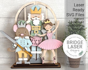May include: A wooden laser-cut Christmas decoration depicting characters from The Nutcracker ballet. The figures include a nutcracker, a mouse, and a ballerina, set against a window-shaped backdrop. The text on the image says "Laser Ready SVG Files".