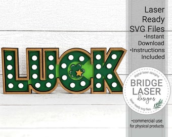 May include: A wooden "LUCK" sign with a green shamrock and gold star in the center of the "C". The sign has a wood frame and white polka dots on a green background.
