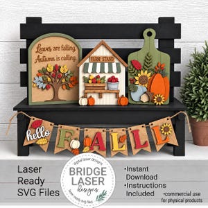 May include: A tiered tray decor set featuring three wooden signs with autumn themes, including a tree with the text Leaves are falling, Autumn is calling, a farm stand, and a cutting board with pumpkins, plus a banner spelling out hello FALL.