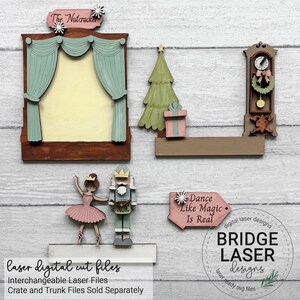 K&ouml;nnte beinhalten: Ein Set aus lasergeschnittenen Holzteilen mit einer Theaterb&uuml;hne mit The Nutcracker-Schild, einem Weihnachtsbaum, einem Geschenk, einer Standuhr, einer Ballerina, einem Nussknacker-Soldaten und einem Schild mit der Aufschrift Dance Like Magic Is Real.