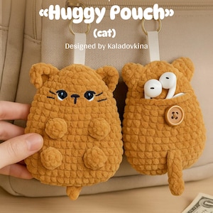 Può includere: Due pochette a forma di gatto all'uncinetto in un caldo colore marrone. Una pochette ha una tasca con auricolari bianchi, fissata con un bottone. L'altra pochette ha tratti del viso ricamati. Il testo "Huggy Pouch" e "Crochet pattern" sono visibili.