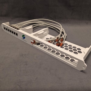 Könnte beinhalten: Weißes Netzwerk-Patchpanel mit grauen Ethernet-Kabeln. Das Panel hat mehrere Ports mit Nummern und dem Logo "WiBean". Das Panel hat ein Wabenmuster und ist für die Aufnahme mehrerer Kabel konzipiert.