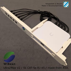 May include: White wall-mounted WiBean Ultra/Max V2 network switch with five RJ-45 ports and black CAT-5e cables. The switch is made from ASA plastic and is labeled "Hergestellt in Bayern. Made in Bavaria/Germany."