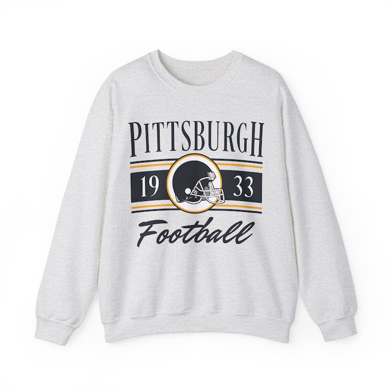 Light ash gray sweatshirt with a retro vintage Pittsburgh Football design on the front, including the founding date (1933) of the Pittsburgh Penguins, and a seating chart layout design of Heinz Field across the back.