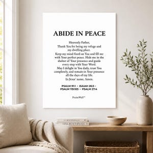 May include: A rectangular white wall art print featuring the black text ABIDE IN PEACE followed by a prayer and scripture references including PSALM 91:1, ISAIAH 26:3, PSALM 119:105, and PSALM 27:4, with the brand name PraiseWell printed at the bottom.