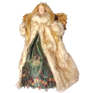 May include: A gold-winged angel figurine with long blonde hair, wearing a green and gold dress and a white faux fur coat.