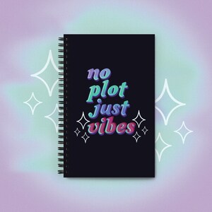 May include: Black spiral notebook with the text "no plot just vibes" in colorful, stylized lettering. White stars surround the text.