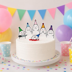 May include: A round white frosted cake topped with six cartoon character cake toppers wearing colorful party hats. One character holds a knife, while another lies on the cake with the number 28 and a red puddle underneath it.