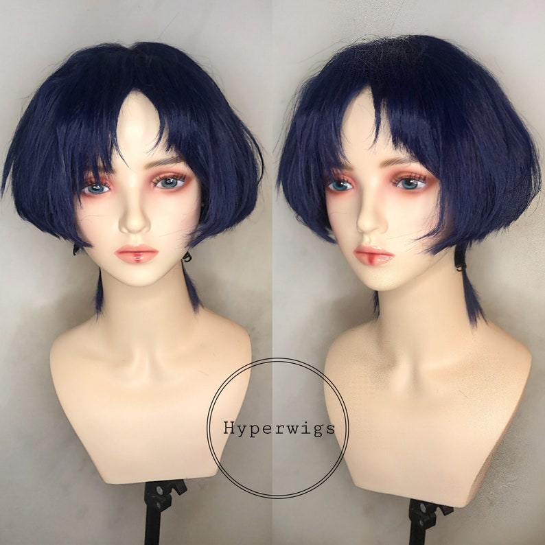 May include: A short, dark blue wig with blunt bangs and a straight, bobbed style. The wig is displayed on a mannequin head.