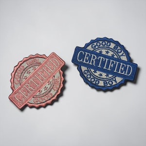 May include: Two embroidered patches with the words "CERTIFIED" and "GOOD BOY" or "GOOD GIRL". One patch is red and the other is blue. The patches are circular with a banner across the middle.