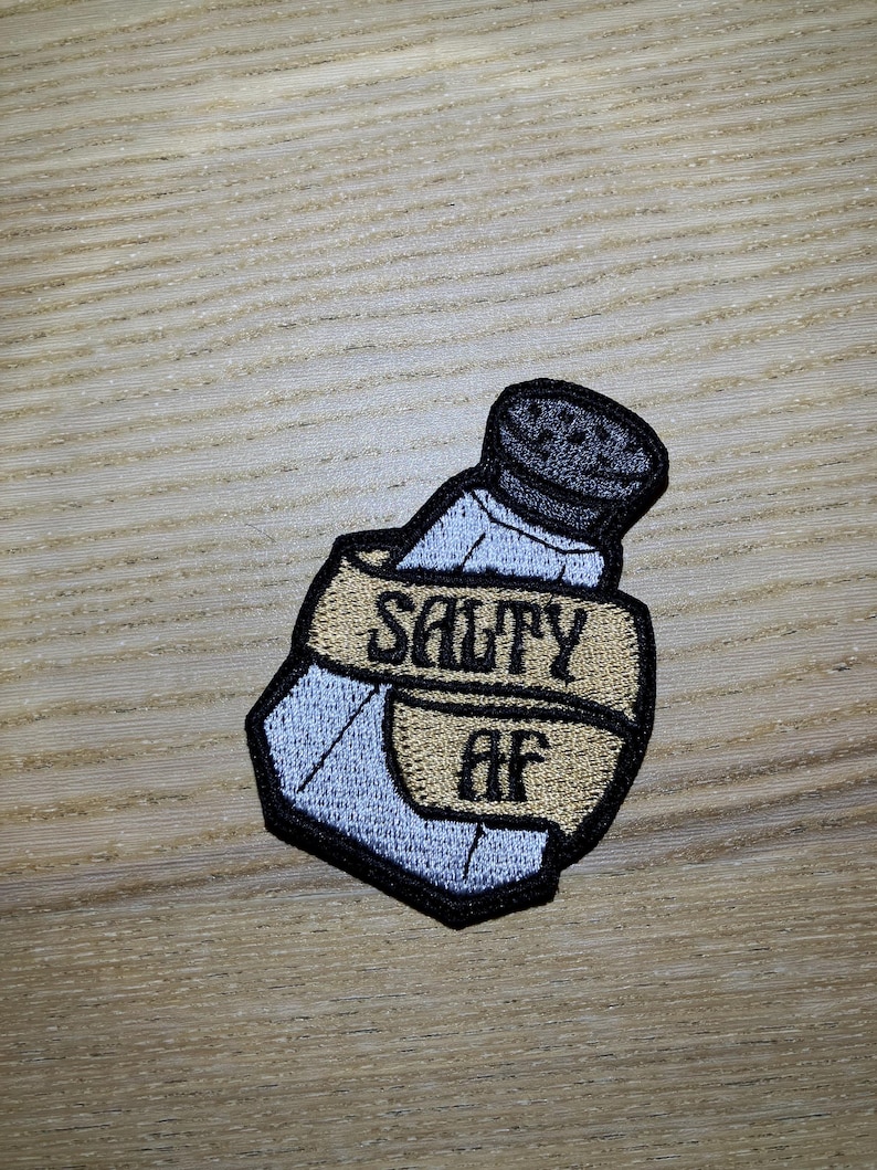 May include: A salt shaker with a gold ribbon wrapped around it that says "Salty AF".