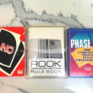 3 juegos de cartas clásicos: ¡UNO, PHASE 10 y ROOK!