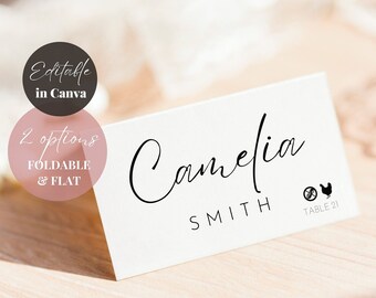 May include: White wedding place card with black calligraphy text that reads "Camelia Smith" and "Table 21".  A no-allergen symbol and a chicken symbol are also included.