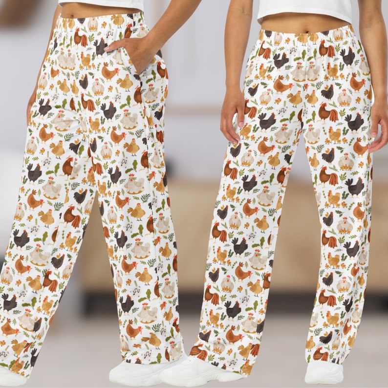May include: White pants with a pattern of colorful chickens and leaves. The pants have an elastic waistband and a relaxed fit.