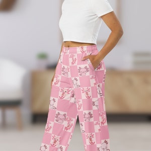 Peut inclure: Pantalon de pyjama &agrave; carreaux roses et blancs avec un motif r&eacute;p&eacute;t&eacute; d'axolotls avec des parapluies et des cornets de cr&egrave;me glac&eacute;e. Le pantalon a une coupe ample confortable et une taille &eacute;lastique. Les axolotls sont dans diverses poses.