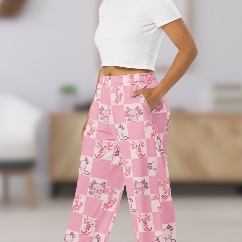 Peut inclure: Pantalon de pyjama &agrave; carreaux roses et blancs avec un motif r&eacute;p&eacute;t&eacute; d'axolotls avec des parapluies et des cornets de cr&egrave;me glac&eacute;e. Le pantalon a une coupe ample confortable et une taille &eacute;lastique. Les axolotls sont dans diverses poses.
