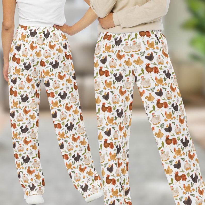 May include: White pajama pants with a repeating pattern of colorful chickens. The pants have an elastic waistband and a relaxed fit.