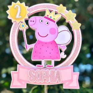 May include: Pink Peppa Pig cake topper with a pink glitter circle, a yellow sun with the number 2, and a pink banner with the name Sophia.