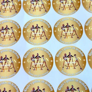 Puede incluir: Pegatinas redondas de papel dorado con el texto "Kaylee's golden 8th birthday" y "Thank you for coming!". Las pegatinas presentan un gr&aacute;fico de tres bailarinas. La palabra "GOLDEN" est&aacute; en el centro.