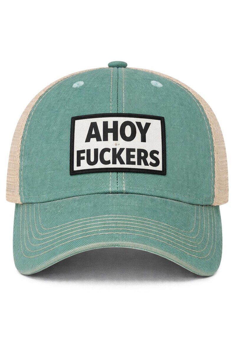 May include: A teal-colored baseball cap with a mesh back and a rectangular patch on the front. The patch features a white background with a black border and the text AHOY FUCKERS printed in bold black capital letters across two lines.