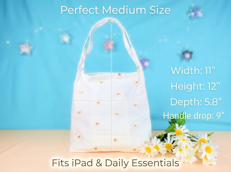 May include: White tote bag with daisy embroidery. The bag is 11 inches wide, 12 inches high, and 5.8 inches deep, with a 9-inch handle drop. The text on the image says "Perfect Medium Size" and "Fits iPad & Daily Essentials."