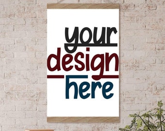 Op de afbeelding: Een witte canvas print met een houten frame hangend aan een bakstenen muur. De print bevat de tekst "your design here" in zwarte, rode en blauwe letters.