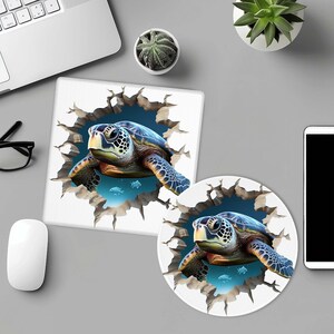 Puede incluir: Dos alfombrillas de ratón redondas con un efecto 3D. Las alfombrillas de ratón presentan una tortuga marina azul y verde que rompe una superficie blanca agrietada. Las tortugas nadan en agua azul con peces pequeños.