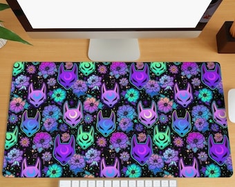 May include: A black mouse mat with a repeating pattern of purple, blue and green fox masks with a crescent moon on their foreheads. The masks are surrounded by pink, white and green flowers on a black background with white stars.