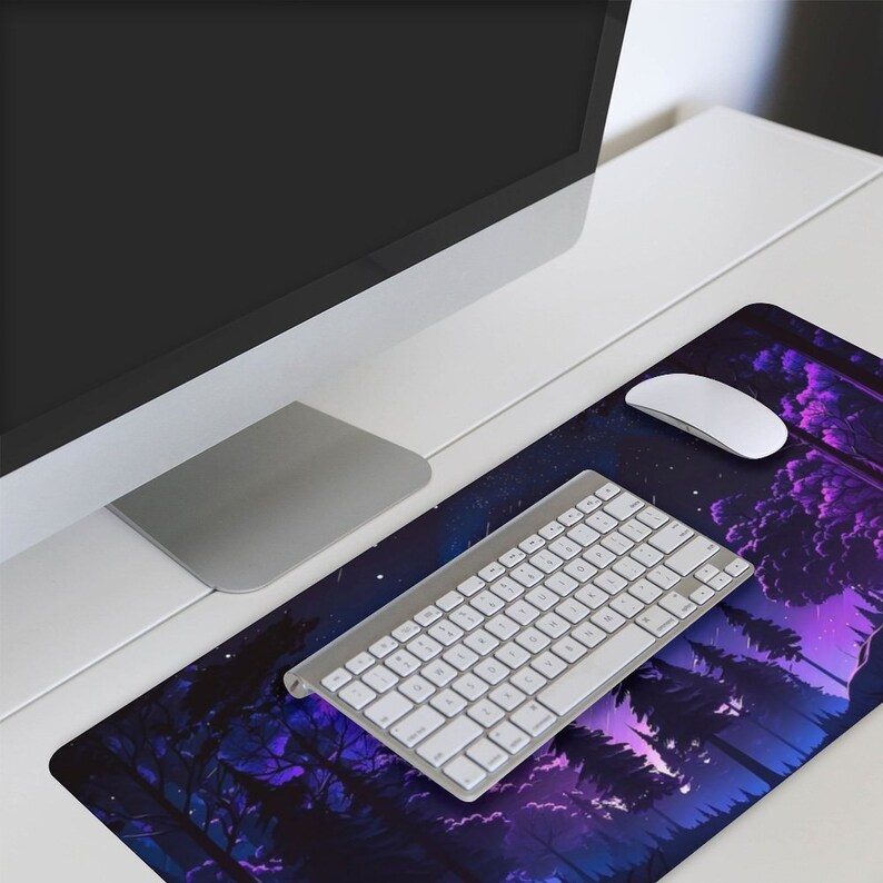 May include: A purple and blue mouse mat with a starry night sky and silhouette of trees. A white wireless keyboard and mouse are on the mat.