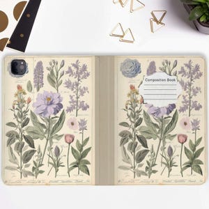 Könnte beinhalten: Ein Vintage-Stil Composition Book Cover mit einem floralen Design mit lila, rosa und grünen Blumen. Das Cover hat den Text "Composition Book" aufgedruckt.