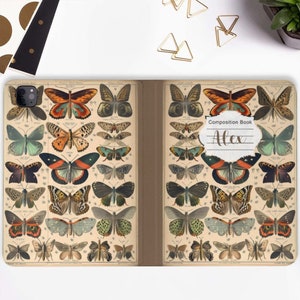 Puede incluir: Una cubierta de cuaderno de composición con un diseño vintage que presenta una colección de mariposas coloridas. La cubierta tiene una etiqueta blanca con el texto "Composition Book" y el nombre "Alex" escrito en cursiva.