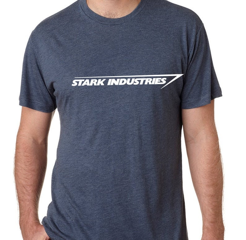Puede incluir: Una camiseta azul oscuro con un gr&aacute;fico blanco del texto "Stark Industries" y una l&iacute;nea diagonal blanca.