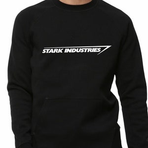 Puede incluir: Sudadera negra con un logotipo blanco de "STARK INDUSTRIES" impreso en la parte delantera.