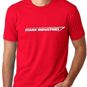 Puede incluir: Camiseta roja con un logotipo blanco de "Stark Industries" y una flecha blanca.