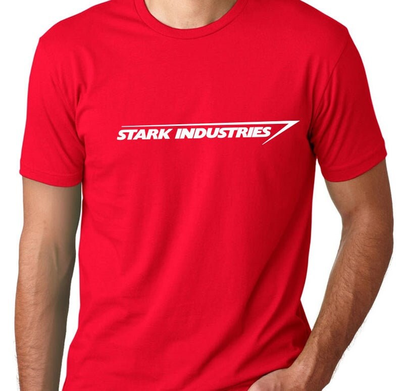 Puede incluir: Camiseta roja con un logotipo blanco de "Stark Industries" y una flecha blanca.