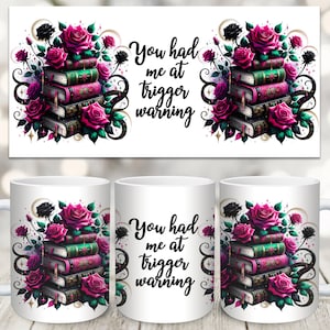 Può includere: Tazza in ceramica bianca con un design floreale nero e rosa che presenta una pila di libri e il testo "You had me at trigger warning".