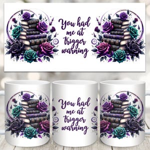 Può includere: Tazza in ceramica bianca con un design floreale viola e verde che presenta una pila di libri e il testo "You had me at trigger warning".