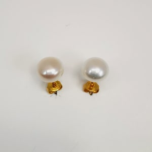 Puede incluir: Un par de pendientes de perlas blancas con postes de oro.