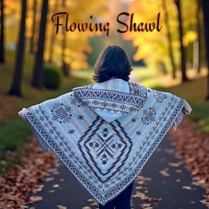 May include: A hooded shawl with a geometric pattern in shades of brown, blue, and cream. The shawl is displayed outdoors with the text "Flowing Shawl" in the upper centre. The shawl has a triangular shape with a fringed edge.