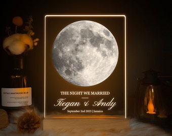 May include: A white illuminated sign with a black background featuring a full moon image and the text "THE NIGHT WE MARRIED Tiegan & Andy September 2nd 2023 | Jamaica".