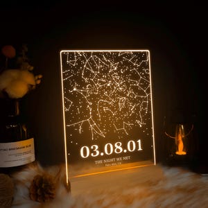 Puede incluir: Una luz LED blanca con un mapa de constelaciones y la fecha 03.08.01. El texto "The night we met" y "Palo Alto, CA" est&aacute;n debajo de la fecha.