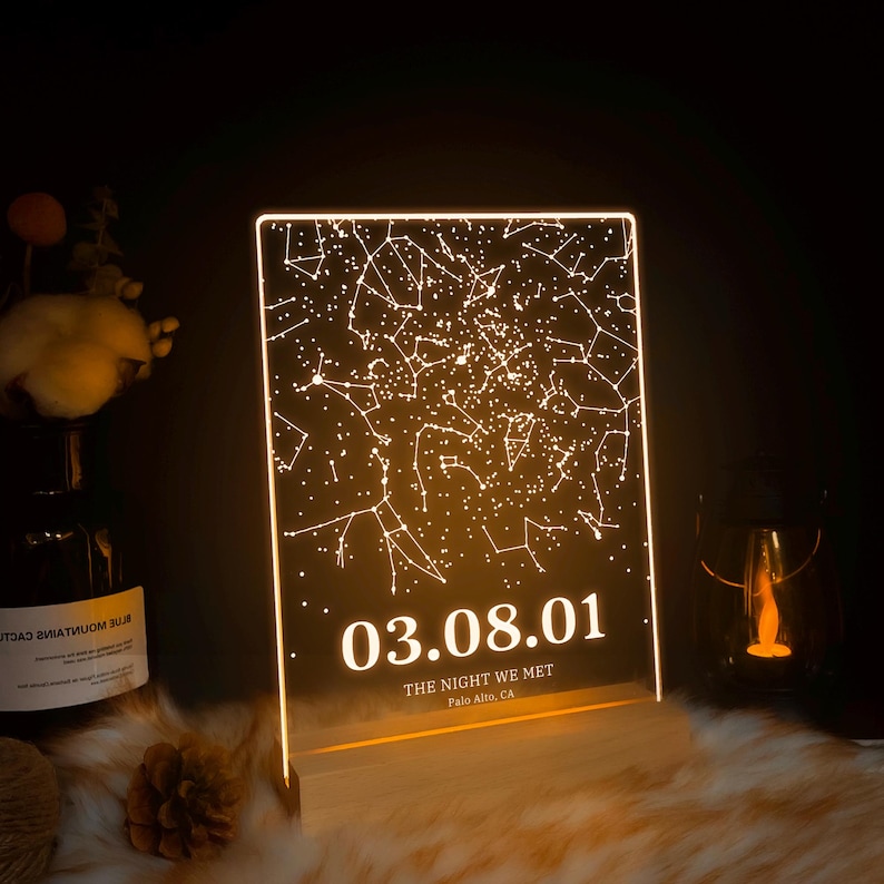 Puede incluir: Una luz LED blanca con un mapa de constelaciones y la fecha 03.08.01. El texto "The night we met" y "Palo Alto, CA" est&aacute;n debajo de la fecha.