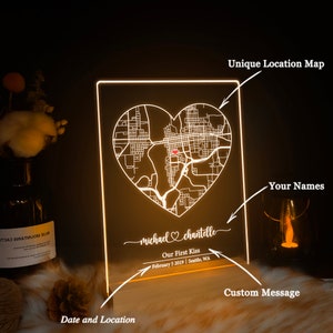 Pu&ograve; includere: Un cartello in acrilico bianco illuminato con una mappa a forma di cuore di una citt&agrave;. Il cartello include i nomi "michael" e "chantelle", il testo "Our First Kiss" e la data "February 5 2019 | Seattle, WA".